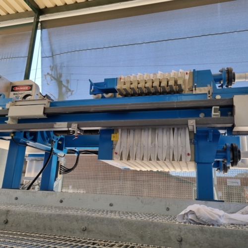 Small automated filter press being used for dewatering sludge form an industrial laundry
